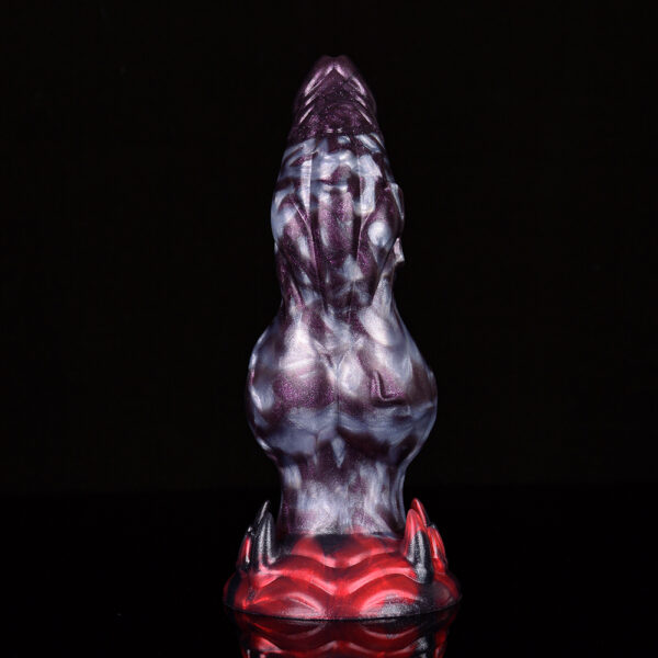 A dragon dildo showcasing its big knot in front of a black background.