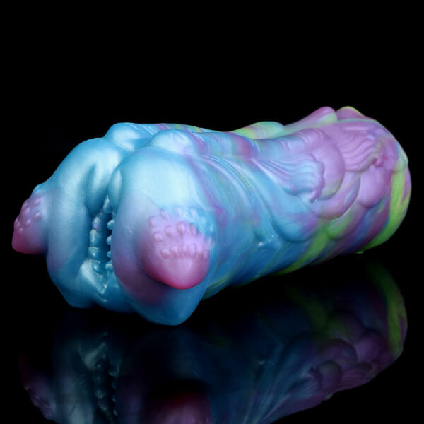 A male masturbator resting on a reflecting black surface. The sex toy features a unique form und vibrant colors.