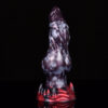 A dragon dildo standing on its suction cup in front of a black background.