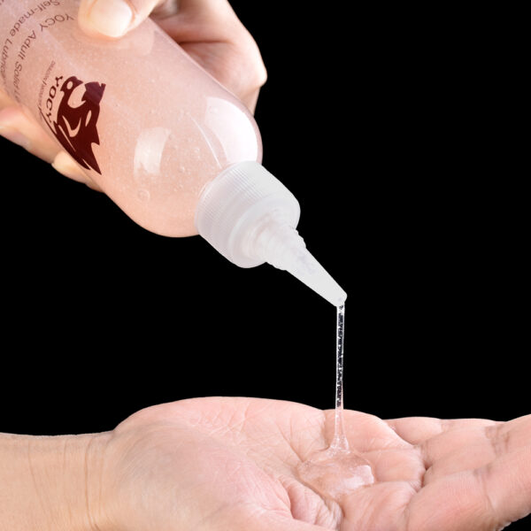 A close-up of a persons hand pouring lubricant, highlighting the liquid form.