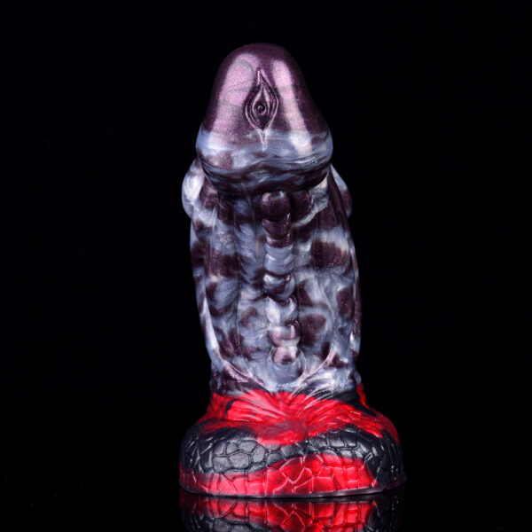A fat dragon dick standing on its suction cup in front of a black background.