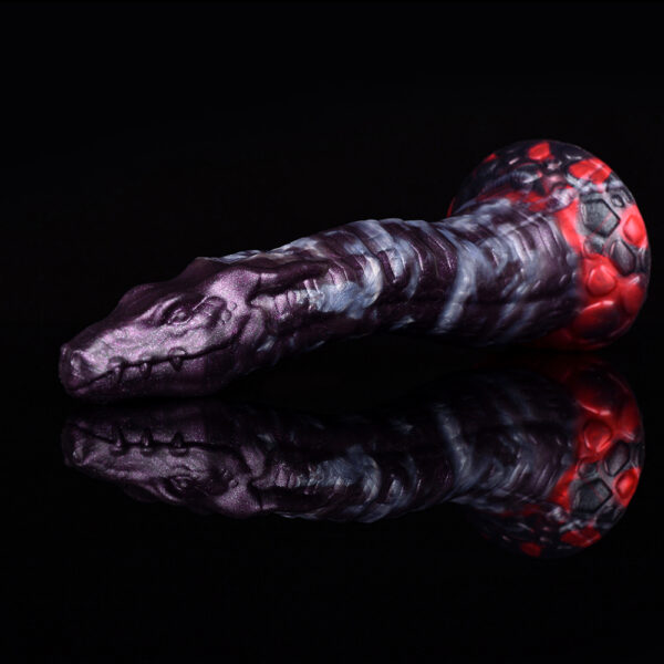 A purple and red snake-shaped dildo resting on a shiny, reflective surface, showcasing its vibrant colors and unique design.