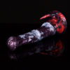 A close up of a fantasy horse dildo laying on a black and reflecting surface with a black background.