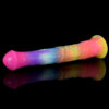 A rainbow-colored horse dildo resting on a sleek black surface, showcasing vibrant colors against a dark backdrop.