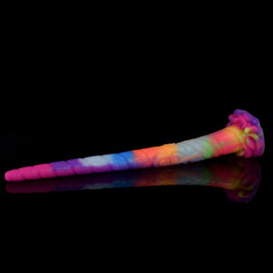 A long and colorful anal dildo with plenty of structure and texture, laying on a black reflecting surface.