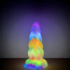 A stunning dildo radiates rainbow hues, beautifully lit and displayed on a table, creating a captivating atmosphere.