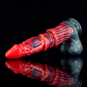 A colorful red and black dildo is displayed on a dark black background, emphasizing its design which is a mix between realistic and fantasy sex toy. The dildo has black balls and a red and black shaft.