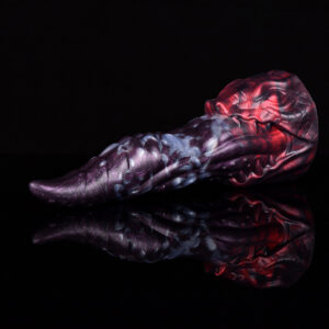 A black and red tonge shaped dildo laying on a black and reflecting surface.