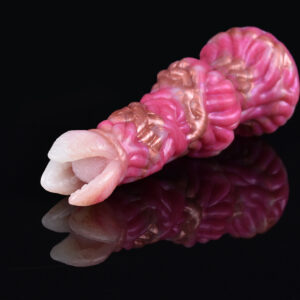 A pink fantasy dildo on a black reflective surface. The dildo has gold features with a big knot and a round tip for g-spot stimulation.